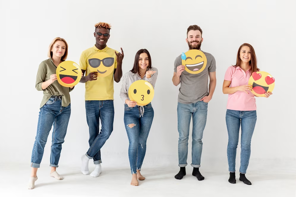 Varias persoas sostendo recortables con emoticonos de distintas emocións