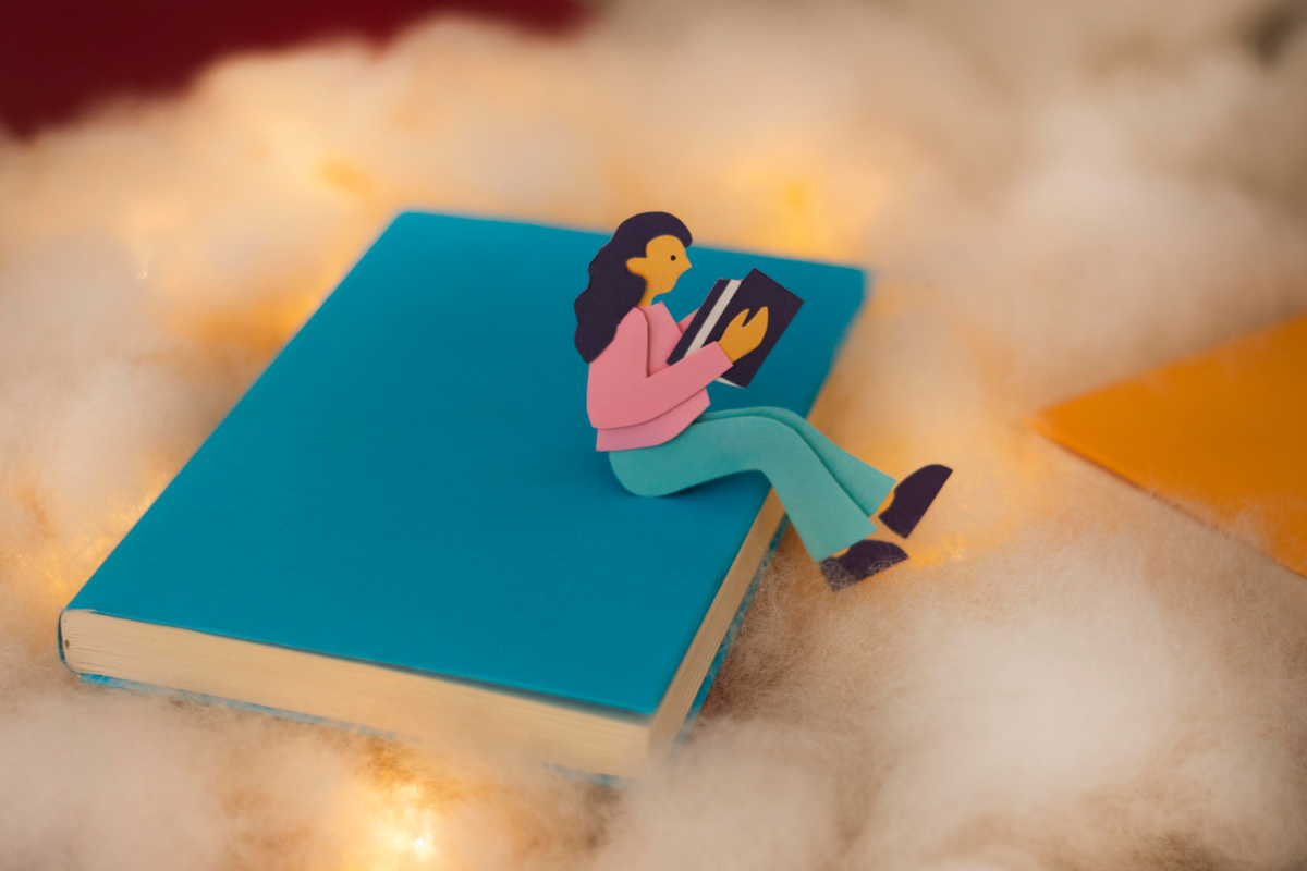 Ilustración de persona leyendo sentada sobre un libro