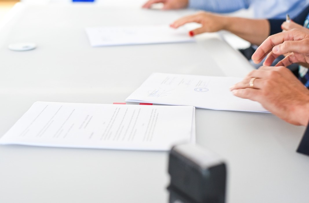 Persoas asinando documentos.